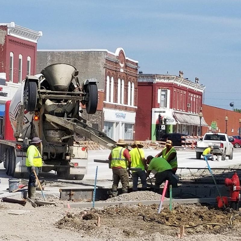 Crew works on pouring fresh concrete in street