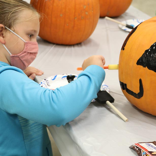Young girl painting pumpkin at a parks and recreation event